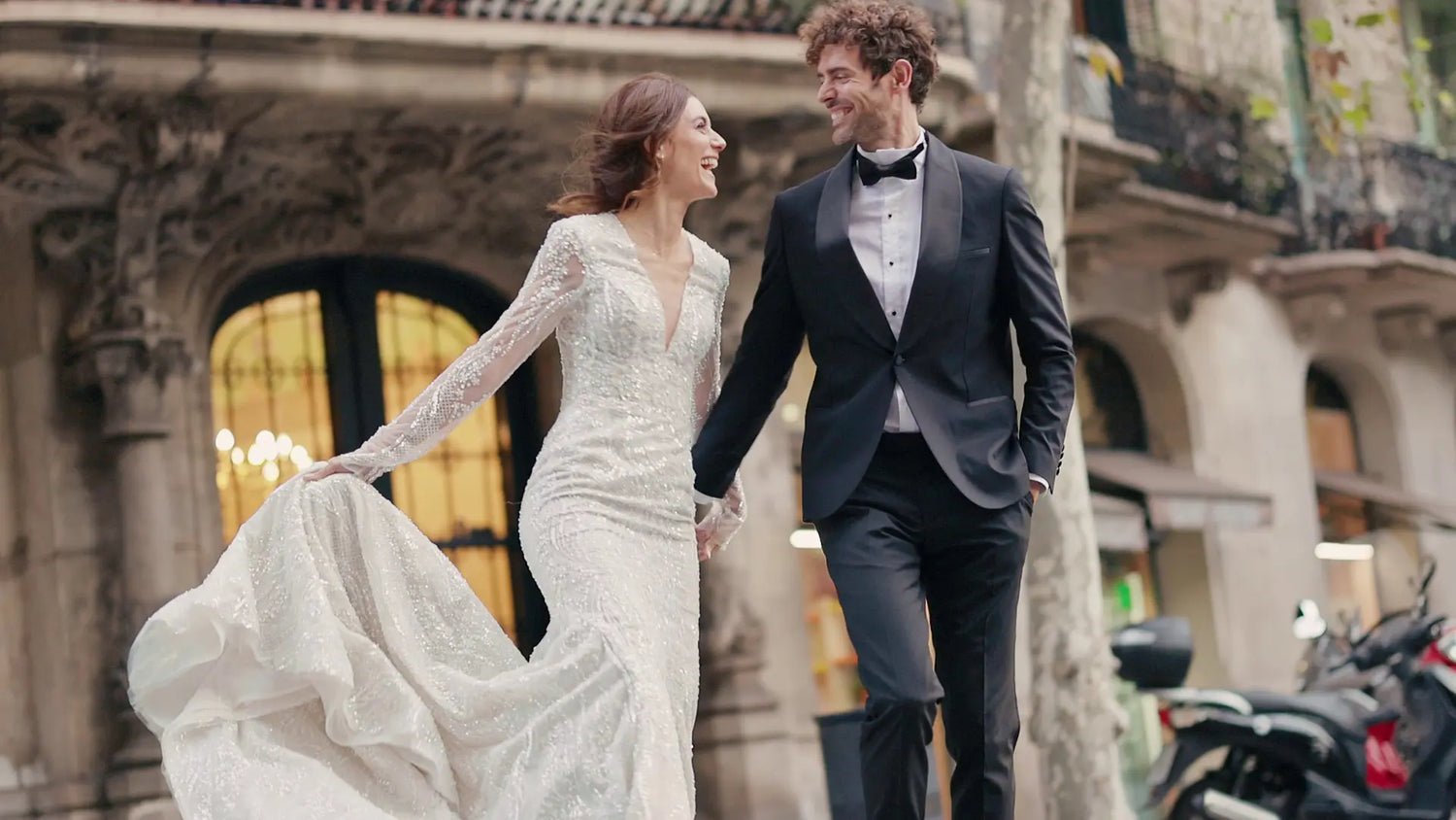 Hochzeitsaccessoires für Herren – Bräutigam im dunklen Smoking mit schwarzer Fliege und Einstecktuch neben der Braut